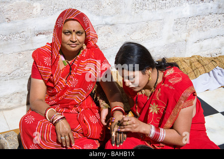 Giovane donna decorazione di sua madre la mano, Sachiya Mata Temple, Osian, vicino a Jodhpur, Rajasthan, India Foto Stock