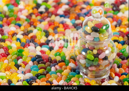 Jellybeans attorno ad un vaso pieno di jellybeans Foto Stock