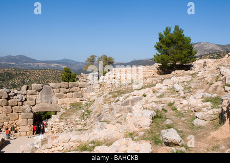 Turisti entrare e lasciare la cittadella di Micene attraverso la Porta del Leone costruito intorno al 1240 A.C. e realizzato dalla pietra di mandorla Foto Stock