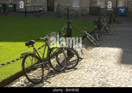 Biciclette tradizionali bloccato contro la catena recinzione al Trinity College di Dublino, Irlanda Foto Stock