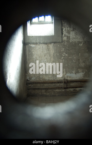 Guardando attraverso l'occhio magico in vuota cella di prigione di Kilmainham Gaol, Dublino, Irlanda Foto Stock