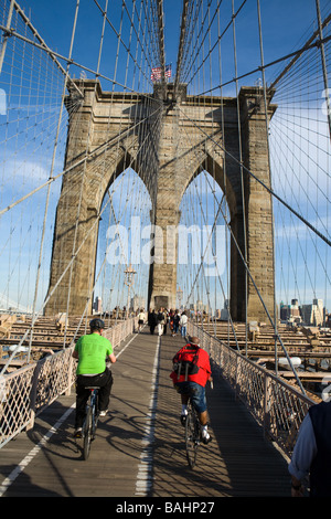 La gente a piedi e in mountain bike attraverso il Ponte di Brooklyn a New York City Foto Stock