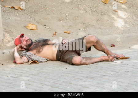 Senzatetto uomo dorme nel sole di mezzogiorno in Rio street Foto Stock