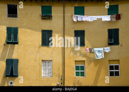 Linee di lavaggio su edifici in Piazza Anfiteatro, Lucca, Toscana, Italia. Foto Stock