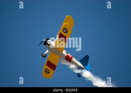 Un US Navy versione del biplano Stearman trainer - in volo e visto da un angolo acuto da sotto. Foto Stock