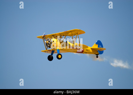 Un US Navy versione del biplano Stearman trainer - in volo e visto da una lieve inclinazione dal basso. Foto Stock