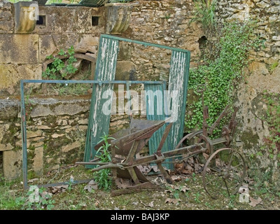 Vecchio arrugginito veicolo agricolo in piedi per un vecchio tugurio nella regione Midi Pirenei Francia Foto Stock