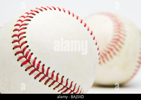 Close-up di 2 poco utilizzato baseballs contro uno sfondo bianco. Messa a fuoco selettiva sul baseball in primo piano. In una serie. Foto Stock