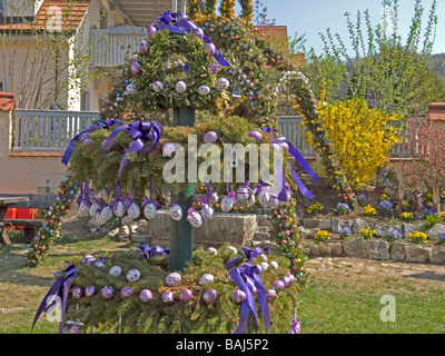 Albero con colorate uova di pasqua in background la decorazione sopra il serbatoio di acqua in Baviera Weißenohe Alta Franconia Germania Foto Stock