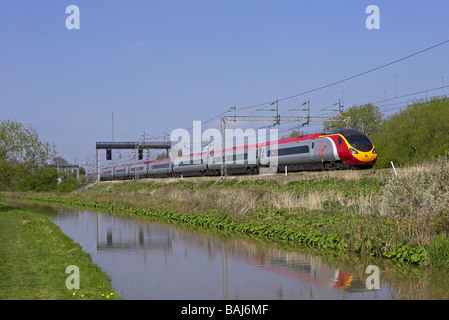 Virgin Pendolino forma un Carlisle Euston servizio attraverso Ansty Coventry con il canale di Oxford in primo piano il 21 04 09 Foto Stock