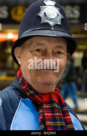 Uomo vestito con Londra poliziotto del casco e sciarpa tartan presso il Tartan Day Parade di New York America Foto Stock