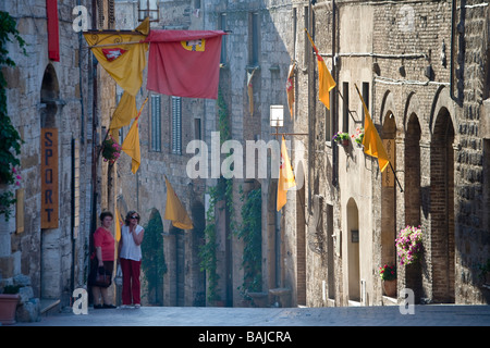 Due donne in strada all'alba a San Gimignano, Toscana, Italia Foto Stock