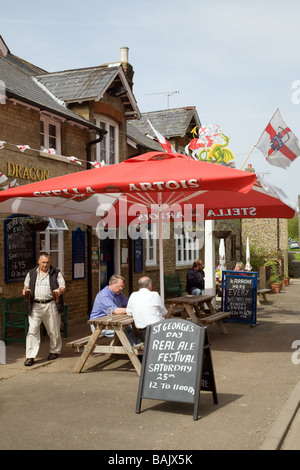 Le persone a bere birra al di fuori del George and Dragon pub, su St Georges giorno, Snailwell, Cambridgeshire Regno Unito Foto Stock