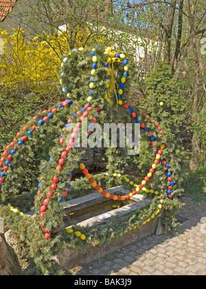 Pasqua ben colorate uova di pasqua a decorazione su di un piccolo serbatoio di acqua in Baviera Weißenohe Alta Franconia Germania Foto Stock