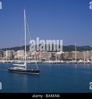 Sailing yacht "Kokomo" con la sua storica il castello di Bellver e il Paseo Maritimo in background, Palma de Mallorca Foto Stock
