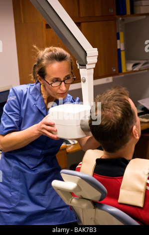 Dentisti assistant prepara un paziente per un x-ray Foto Stock