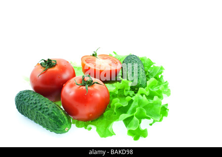 Due e mezzo rosso di pomodori e cetrioli di due su foglie di lattuga Foto Stock