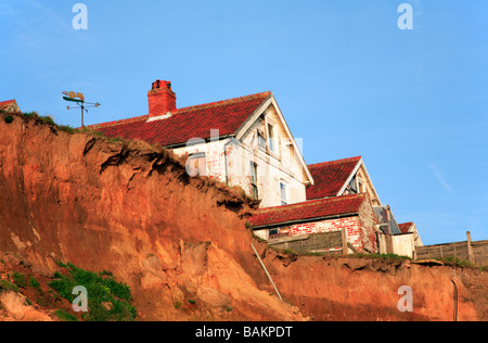 Gli edifici sul bordo della scogliera di erosione a Happisburgh, Norfolk, Regno Unito. Foto Stock