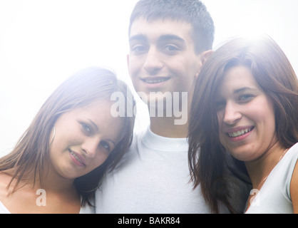 Tre giovani felici amici in piedi insieme e sorridente Foto Stock