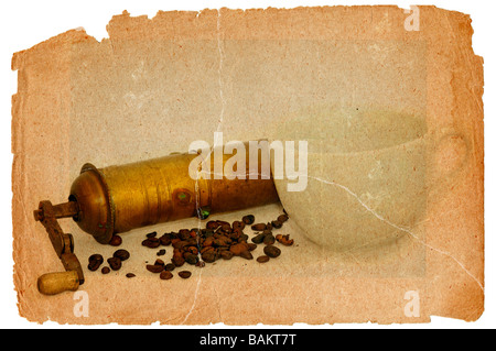 Antica macina caffè con i chicchi di caffè e la tazza bianca Foto Stock