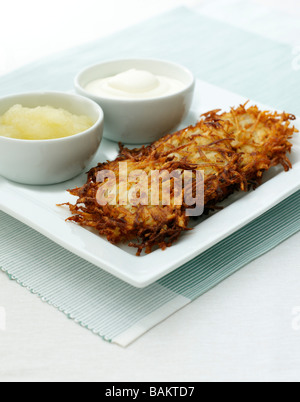 Frittelle di patate o latkes servita con Apple e panna acida Foto Stock