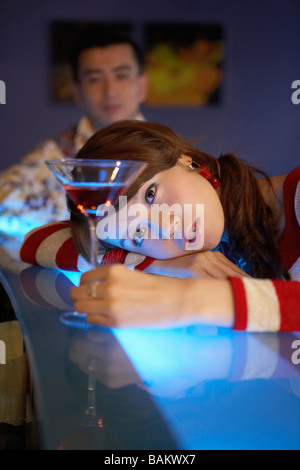 Donna che mantiene coppetta Martini presso il Bar Foto Stock