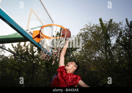 Giocatore di basket tiri a canestro Foto Stock
