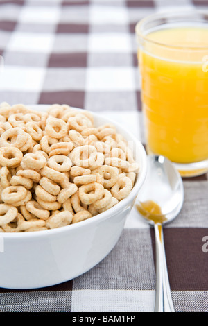 Ciotola di cereale e un bicchiere di succo di arancia Foto Stock