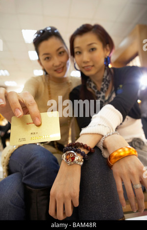 Due giovani ragazze che posano per una fotografia con carta di credito Foto Stock