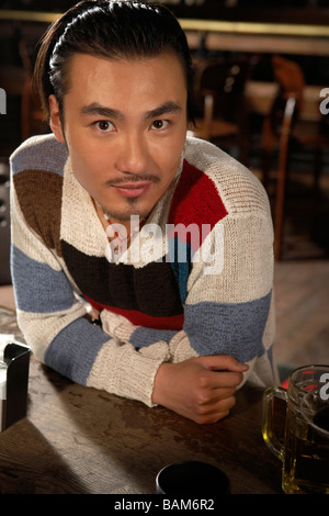 Giovane uomo seduto al bar Foto Stock