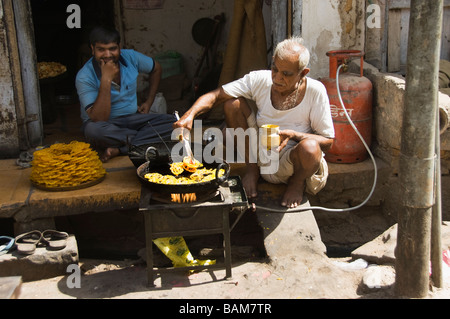 Uomo indiano che prepara ciambelle per strada Jaisalmer, India Foto Stock