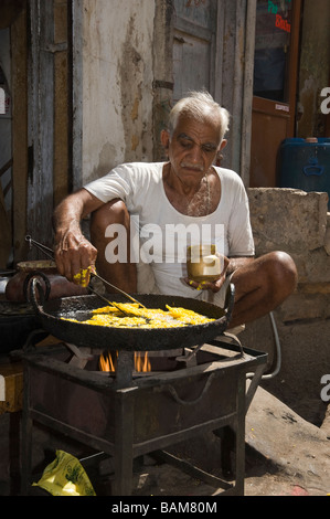 Uomo indiano che prepara ciambelle per strada Jaisalmer, India Foto Stock