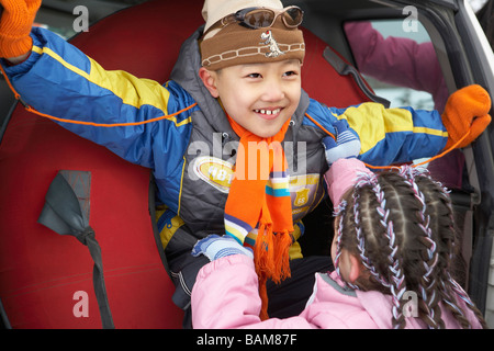 Ragazza ragazzo di trazione al di fuori del tubo di sci Foto Stock