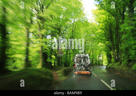 Van trasportano mountain bike aziona un wet strada forestale nel Parco Nazionale di Exmoor, Inghilterra Foto Stock