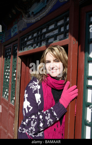 Donna appoggiata contro una porta nella Città proibita Foto Stock