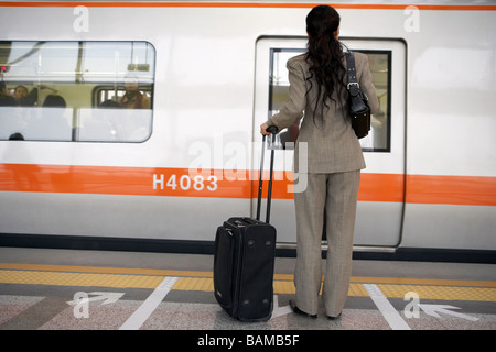 Imprenditrice di attesa per le porte del treno per aprire Foto Stock