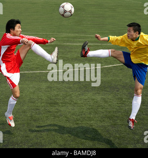 Due giocatori di calcio salto per la sfera Foto Stock