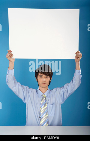 L'uomo mantenendo la grande pezzo di carta Foto Stock