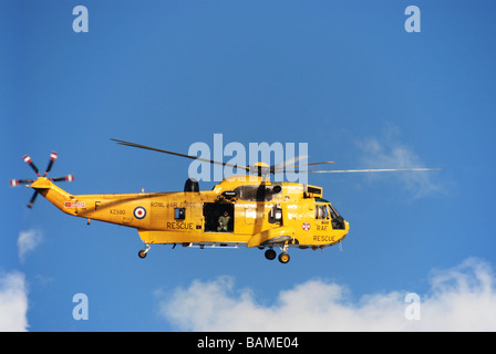 Elicottero Sea King la ricerca e il salvataggio di RAF giallo SARS battenti vista laterale blu cielo nuvola bianca Foto Stock