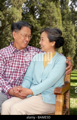 Coppia senior seduto su una panchina nel parco insieme Foto Stock