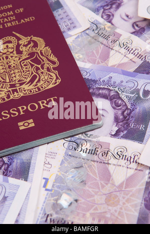 Passaporto britannico su un mucchio di soldi britannico Foto Stock
