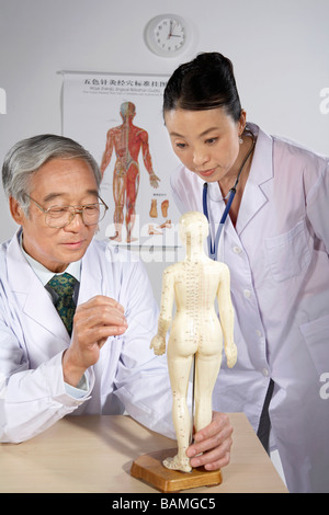 Medico e infermiere su disegno di agopuntura umana figurina Foto Stock