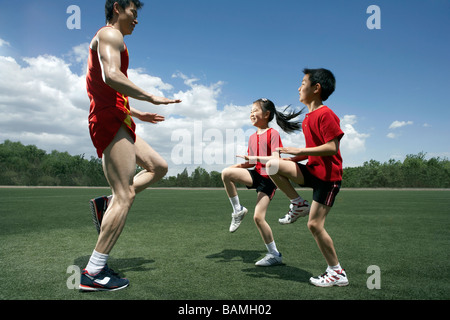 Bambini e coach in esecuzione sul posto Foto Stock