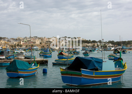 Tradizionali barche da pesca chiamato Luzzu ormeggiata in banchina del villaggio maltese di Marsaxlokk Malta Foto Stock