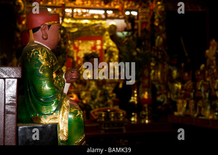 Piccola statua del vestito di verde manto e puntare il dito divinità in un tempio buddista di Sanxia (Sansia) in Taiwan Foto Stock