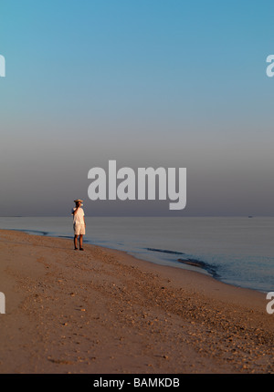 Un uomo cammina sulla spiaggia del mare di Giava a Lombok Indonesia. Foto Stock