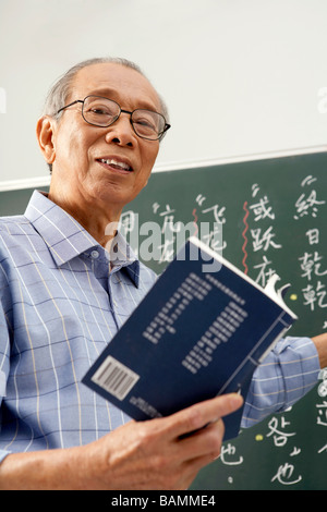 Insegnante Libro di lettura e scrittura su lavagna Foto Stock