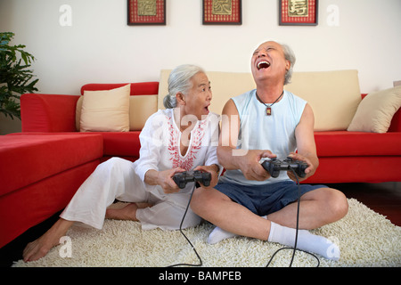 Coppia di anziani nei videogiochi, ridendo Foto Stock