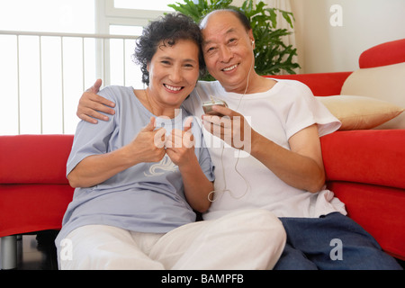 Giovane ascoltando MP3 Player insieme sorridente Foto Stock