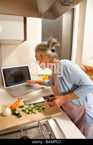 Donna anziana in cucina Foto Stock